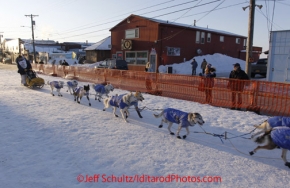 Sunday March 18, 2012    Dan Seavey, mushing to celebrate the 100th anniversary of the historic Iditarod Trail runs in the finish chute in Nome. Iditarod 2012.