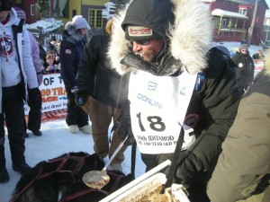 lance feeds the dogs at the finish line